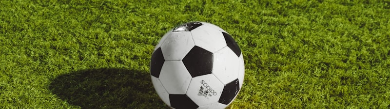 欧冠决赛对阵双方球队的队徽并列展示，背景是闪耀的冠军联赛奖杯