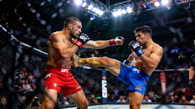 UFC格斗之夜比赛现场，选手在八角笼内进行激烈站立对攻